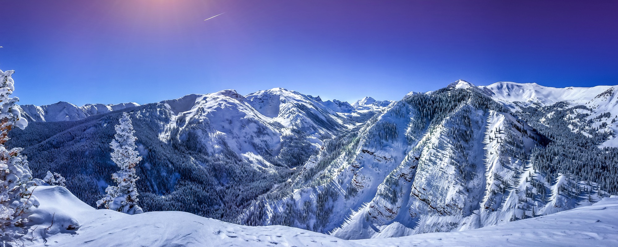 Majestic Mountain Vista (Skiing Header) A serene landscape photo of snow-capped mountains and a clear blue sky.
